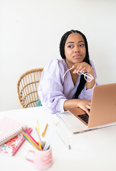 Black woman in front of a laptop contemplating website design