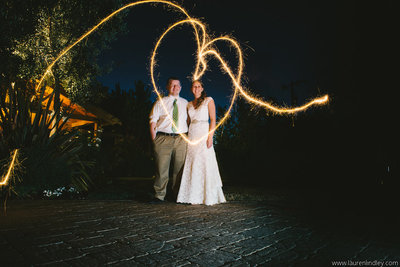 Couple at night, with sparkler heart around them backyard wedding