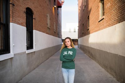 College senior poses for grad photos in an alley way in Old Towne Orange