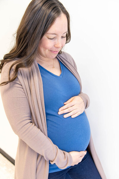 Pregnant women gently holding her belly