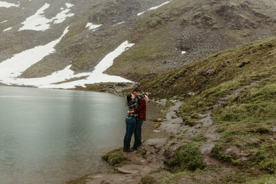 couple standing next to a lake together