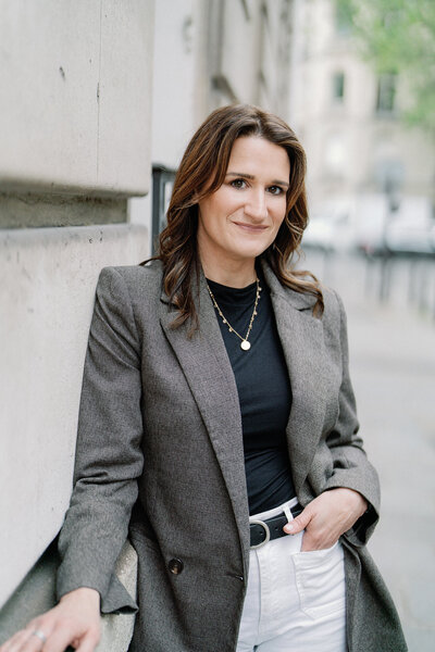 Photographer headshot looking away from camera smiling while sitting with arms crossed on lap