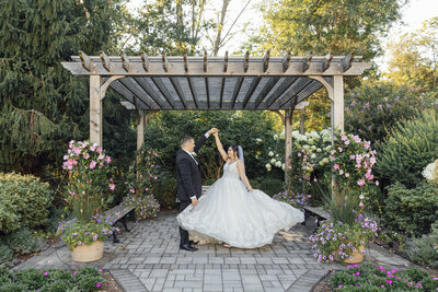 The Palace at Somerset Park Wedding | Groom Spinning Bride by Gazebo with Flowing Dress and Flowers | Somerset, New Jersey