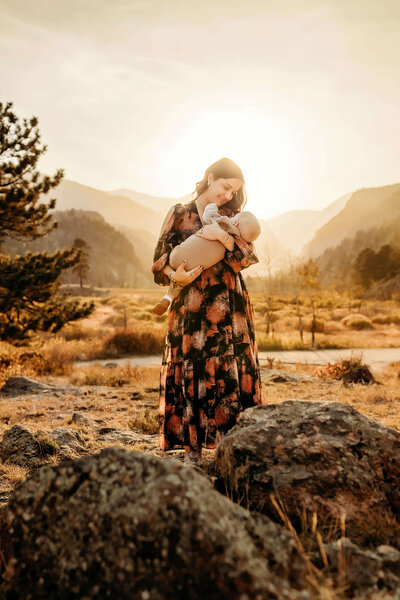 Mom holding son infant son at sunset in the Rocky Mountains of Colorado