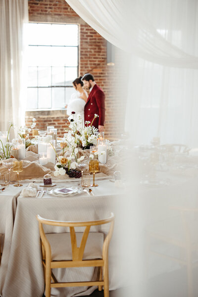 Intimate wedding setup with soft neutral tones and romantic couple in industrial loft venue