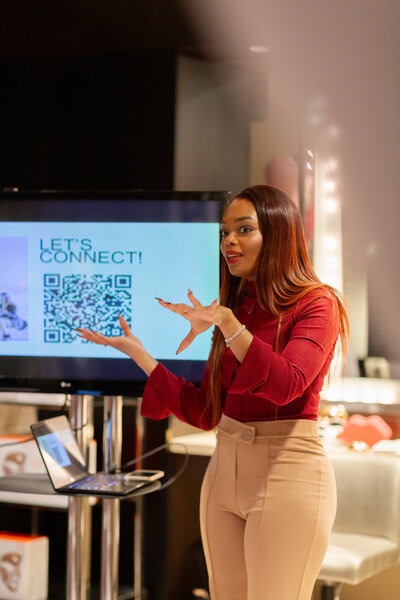 Tahirah sitting on a purple couch holding up "the knot" magazine