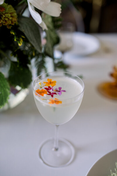 An artistic cocktail topped with edible flowers 