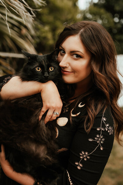 Aspen Dawn holding her black cat.