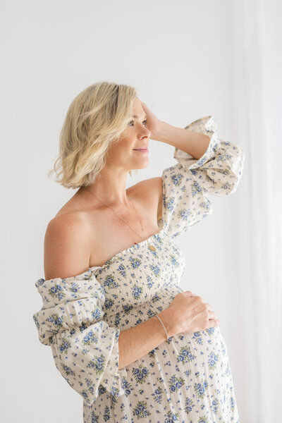 Pregnant mother looking dreamily to the distance in photography studio