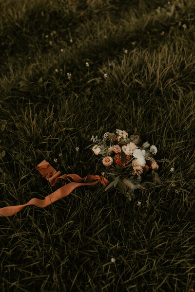 bouquet in grass at barn wedding venue in Wisconsin