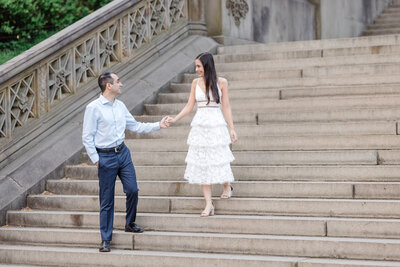 New York City sunrise engagement photo of a women being led down steps in NYC's Central Park.