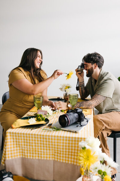 A person sitting on a chair as their partner leans on their back