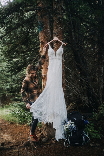 bride looking at dress before her Colorado Elopement Photography session