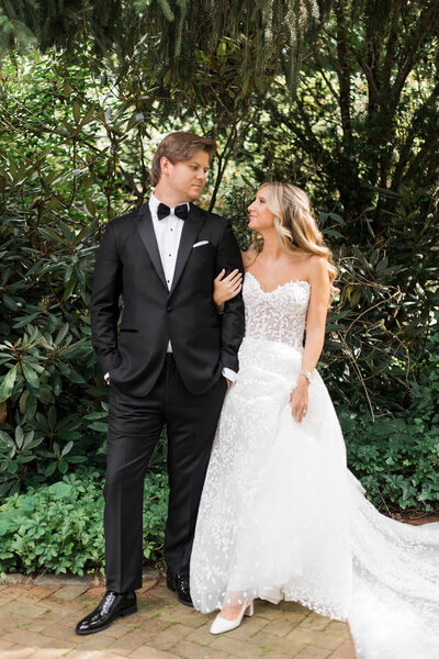 Bride and groom with linked arms looking at each other