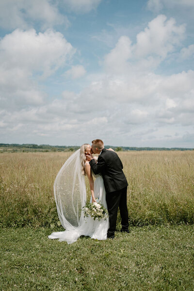 Bride and groom posing in a field at willowbrook