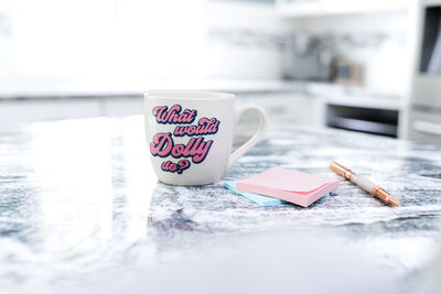 laptop of showit designer on kitchen island next to a coffee mug