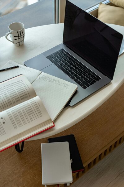 Laptop on desk with book