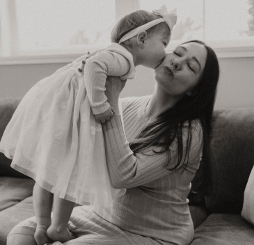 A baby kissing a Mother's cheek for a photo