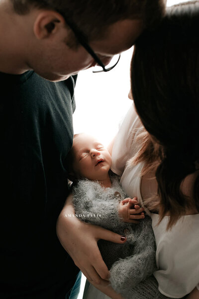Intimate family portrait of parents with newborn