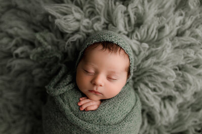 Newborn in studio session wrapped with bonnet