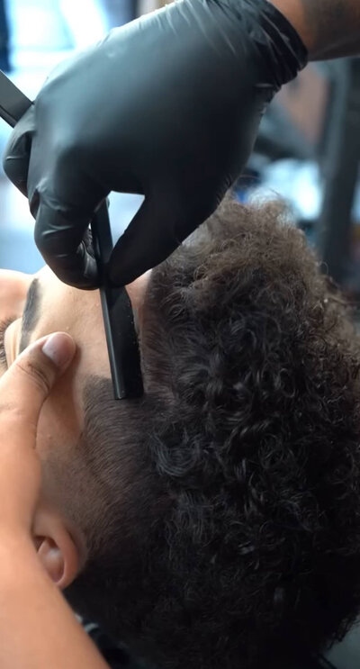 Barber at Onyx Barbershop giving a clean line up and haircut in Wildomar, California.