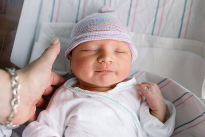 One day old baby boy laying in hospital bassinet