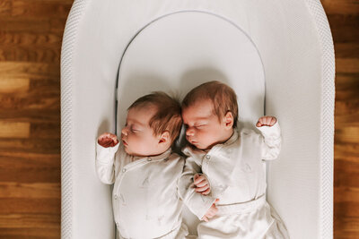 two newborn boys sleeping in a snoo together in their DC home
