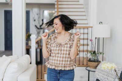 A woman holding a computer advertising the CRM tool Dubsado