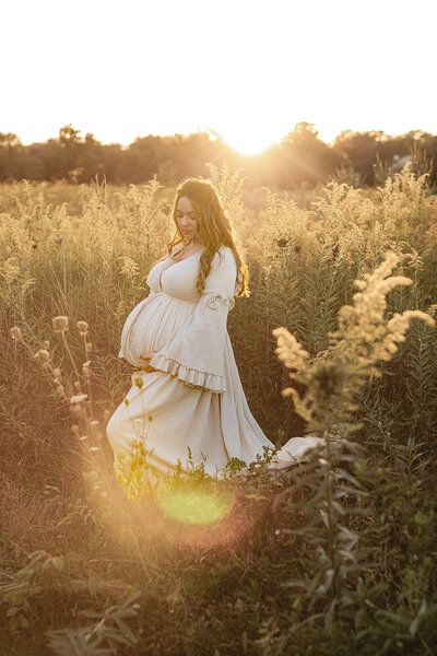 Pregnant woman stands in a field of flowers golden hour Milwaukee Wisconsin