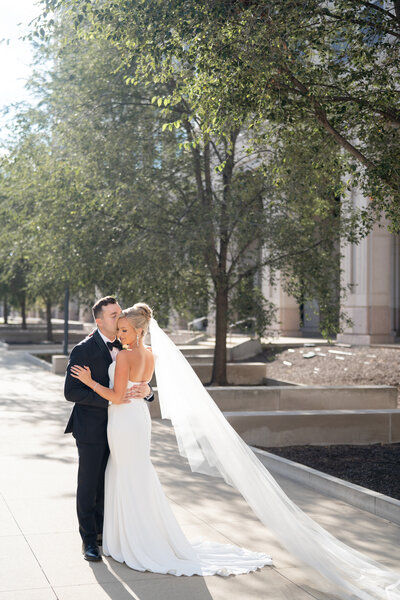 Bride and Groom walking in front of Greencrest Manor in a Black tux and a Berta Wedding gown