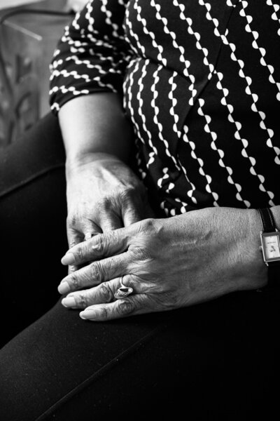 Elderly woman's hands folded in lap