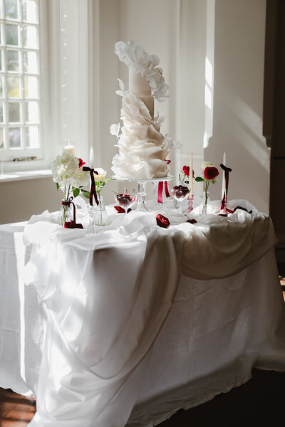 White wedding cake on table with candles in jersey