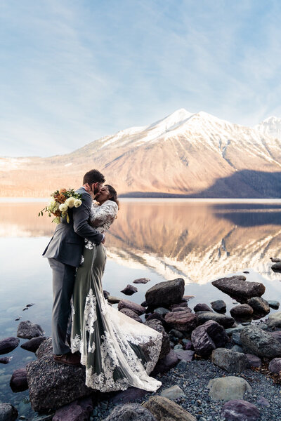 bride and groom kissing at lake mcdonald.