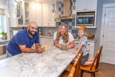 Parents with their toddler son, holding coffee cups and leaning over a counter at their home in Greenwich, CT.