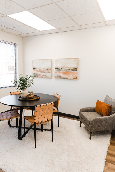 Dena smiling while standing in her beautiful therapy office