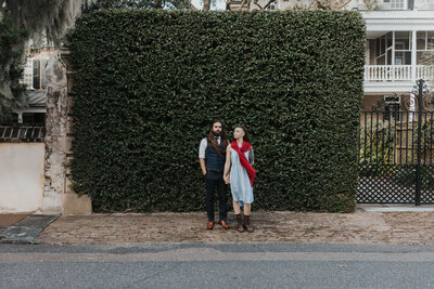 couple stands in front of ivy wall
