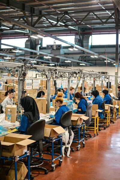 Team of diverse female manufacturing employees work on an assembly line