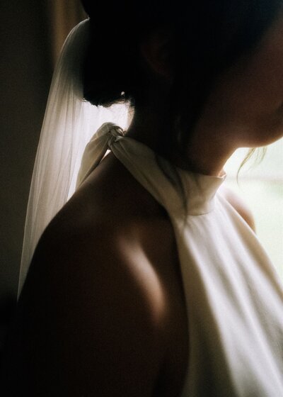 Lovely details of light and shadow falling on bride's shoulder.