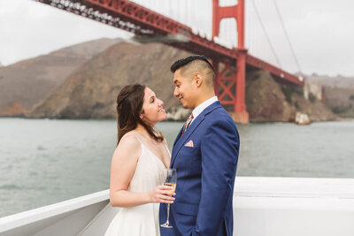 couple celebrating wedding day on cruise under golden gate bridge