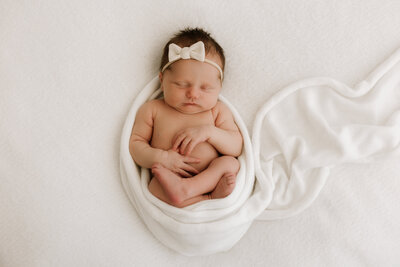 baby smiling while being held in olive green blanket