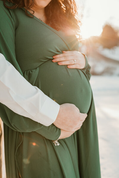 Expecting mother holding her baby bump for maternity pictures in Bucks County 