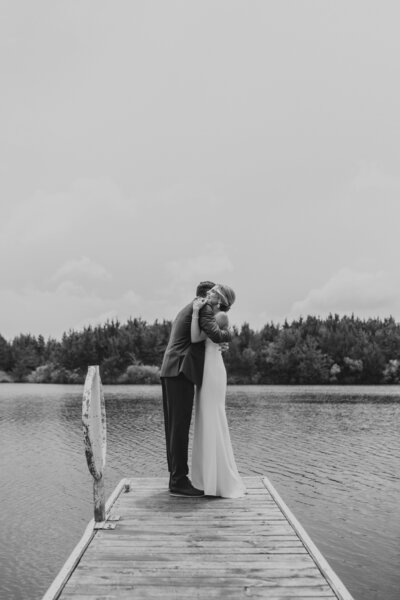 bride and groom hug on dock