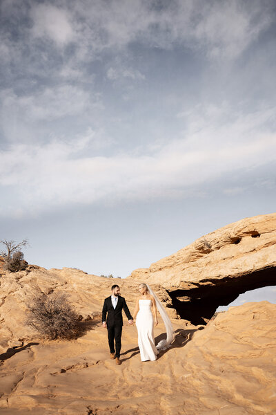 Gold wedding rings on a bride and groom getting married in Moab Utah. 