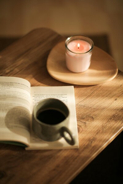 mug on a book with a candle lit on the table