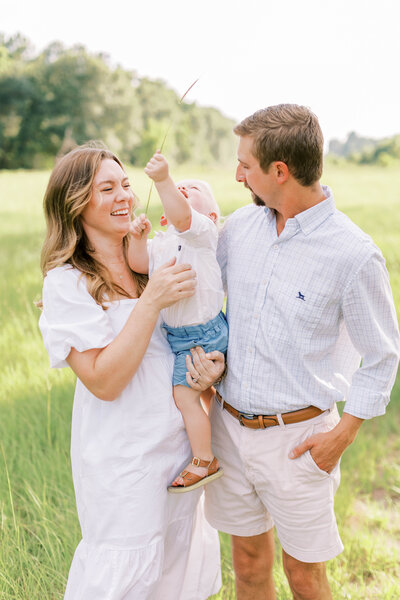 Outdoor portrait of mom and dad holding their little kids in between them
