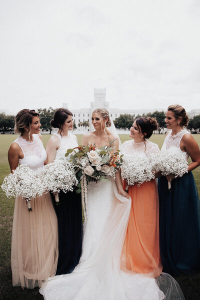 Brides with bridesmaids holding  bouquets and wearing different color skirts