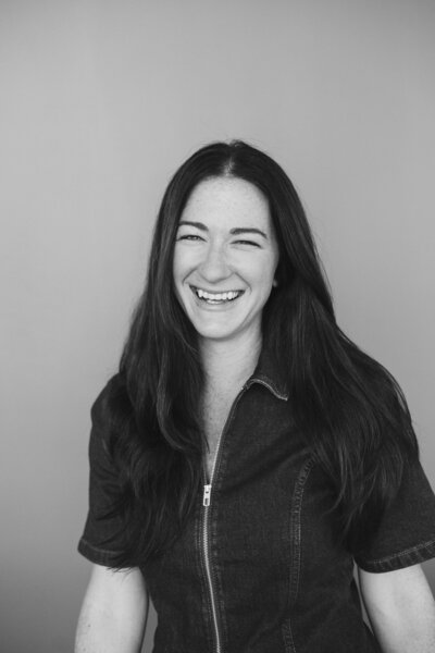 Melissa Stuckey sitting on a couch smiling