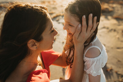 mom holding her son with her daughter hugging her from behind.