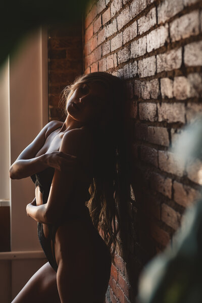 girl with long hair looking over shoulder for her boudoir session in Nashville