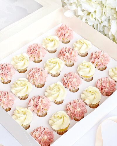 A box of pink & white cupcakes